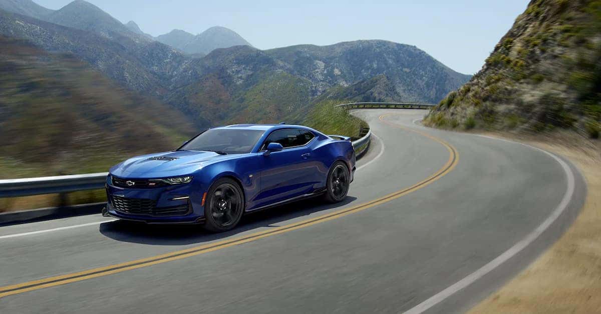 Blue Chevrolet Camaro driving on a mountain road.
