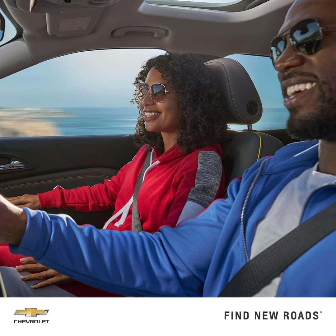 two happy people riding the Chevy Trax on the front seat