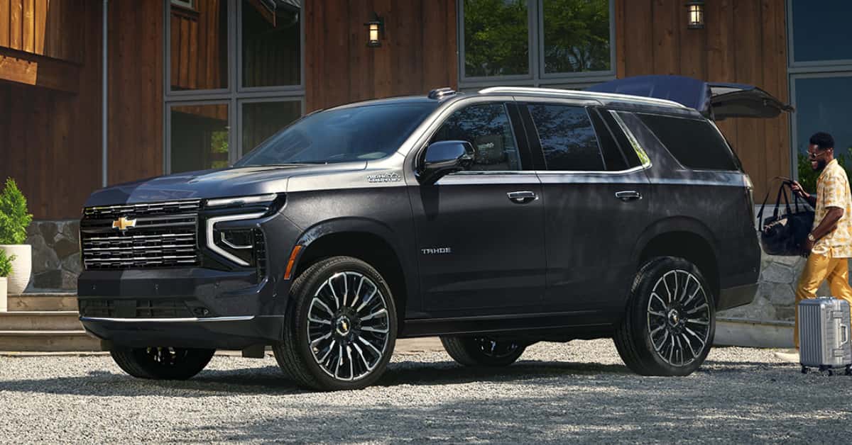 2025 Chevrolet Tahoe parked with a guy loading the rear cabin
