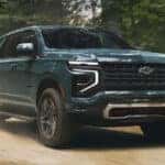 2025 Chevrolet Tahoe driving through a wooded path