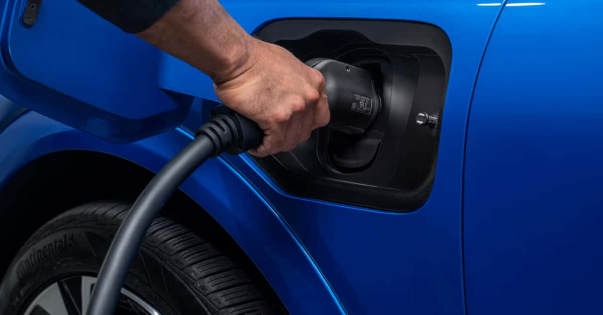 a-man-charging-the-2025-Chevy-Equinox-EV