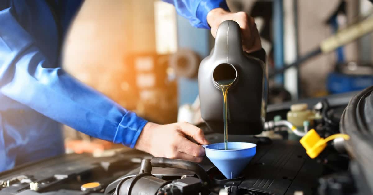 Man pouring engine oil using a funnel