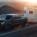 2025-Chevy-Silverado-1500-High-Country-Trim-hauling-a-trailer-on-the-road