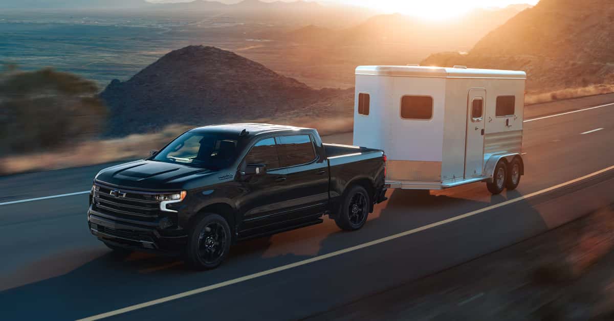 2025-Chevy-Silverado-1500-High-Country-Trim-hauling-a-trailer-on-the-road