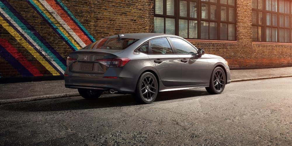 A gray 2026 Honda Civic sedan parked beside a brick building