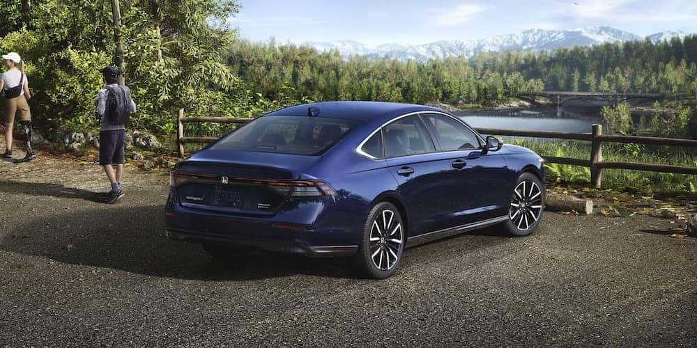 Hikers walking near a blue 2026 Honda Accord sedan parked at a scenic overlook