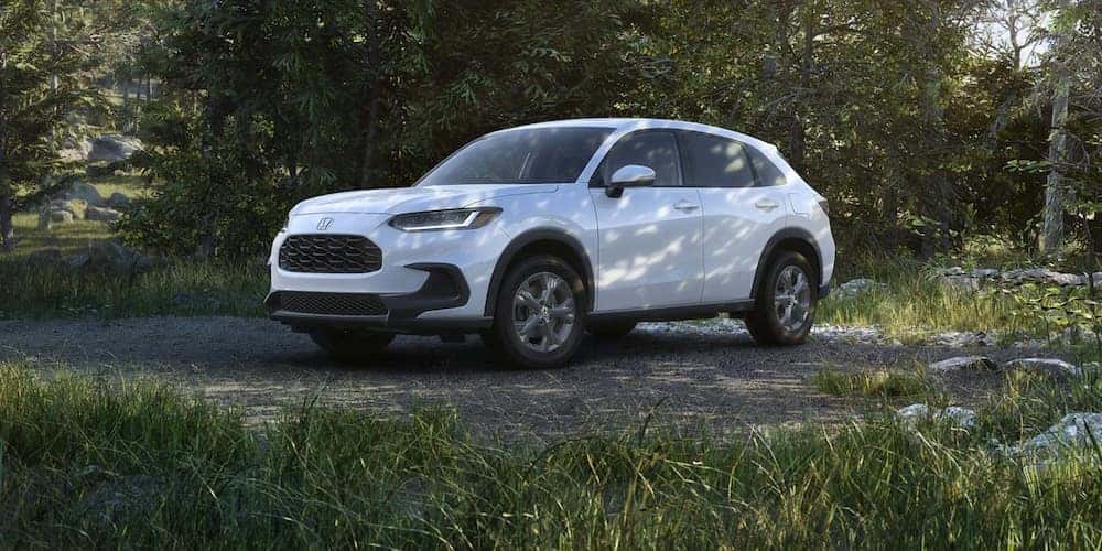 A white 2027 Honda HR-V crossover parked in a wooded area