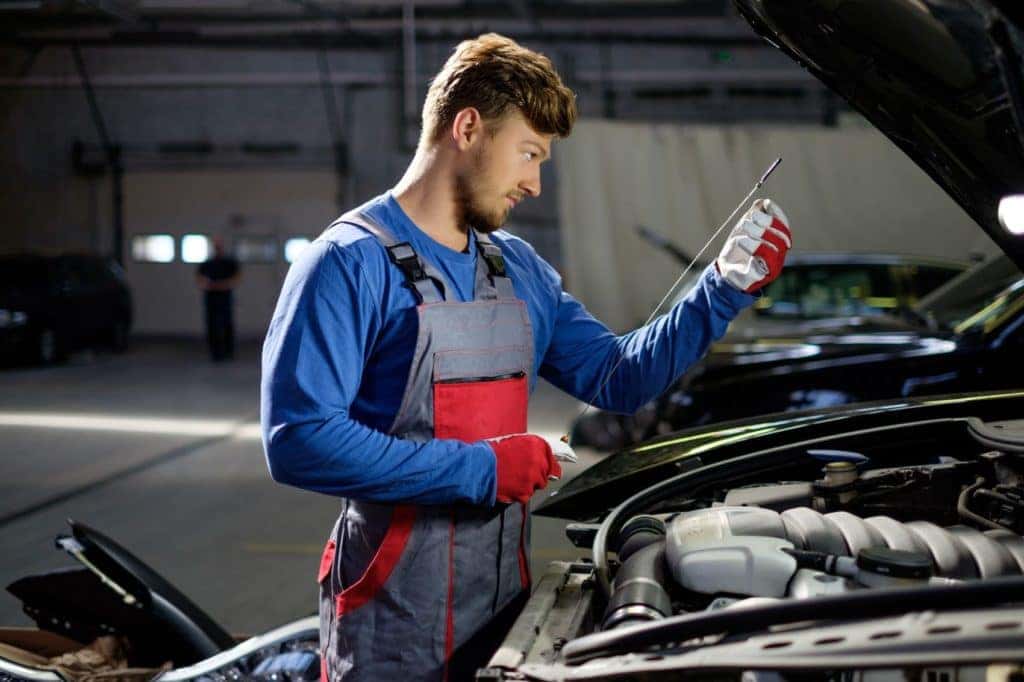 Technician Checking Engine Oil Levels