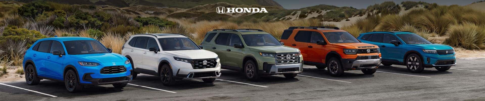 Front three-quarter view of five Honda SUVs in various trims and colors in a coastal parking lot.
