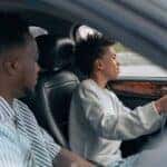 Man in White and Black Striped Dress Shirt Driving Car