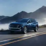 blue hyundai tucson suv driving on highway with mountains in background