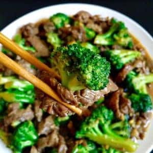 chinese broccoli and beef being held with chopsticks