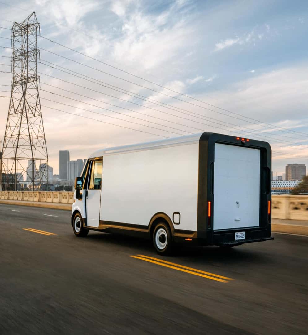MY25 Brightdrop 600 EV Hybrid driving on city highway at sunset