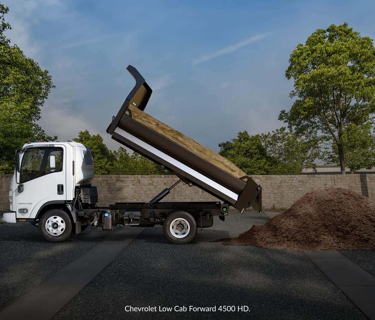 Profile view of a Chevrolet Low Cab Forward dump truck in White with its truck bed tilted up.