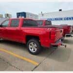 Red Silverado with Yellow Hail Circles Outside Knoepfler Chevrolet Collision Center