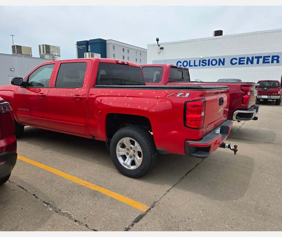Red Silverado with Yellow Hail Circles Outside Knoepfler Chevrolet Collision Center