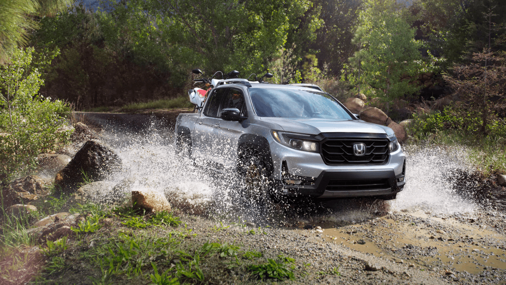 A silver 2021 Honda Ridgeline driving through a stream
