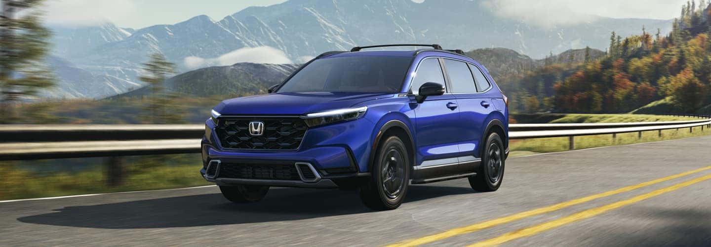 A blue Honda cr-v parked on a dirt road.
