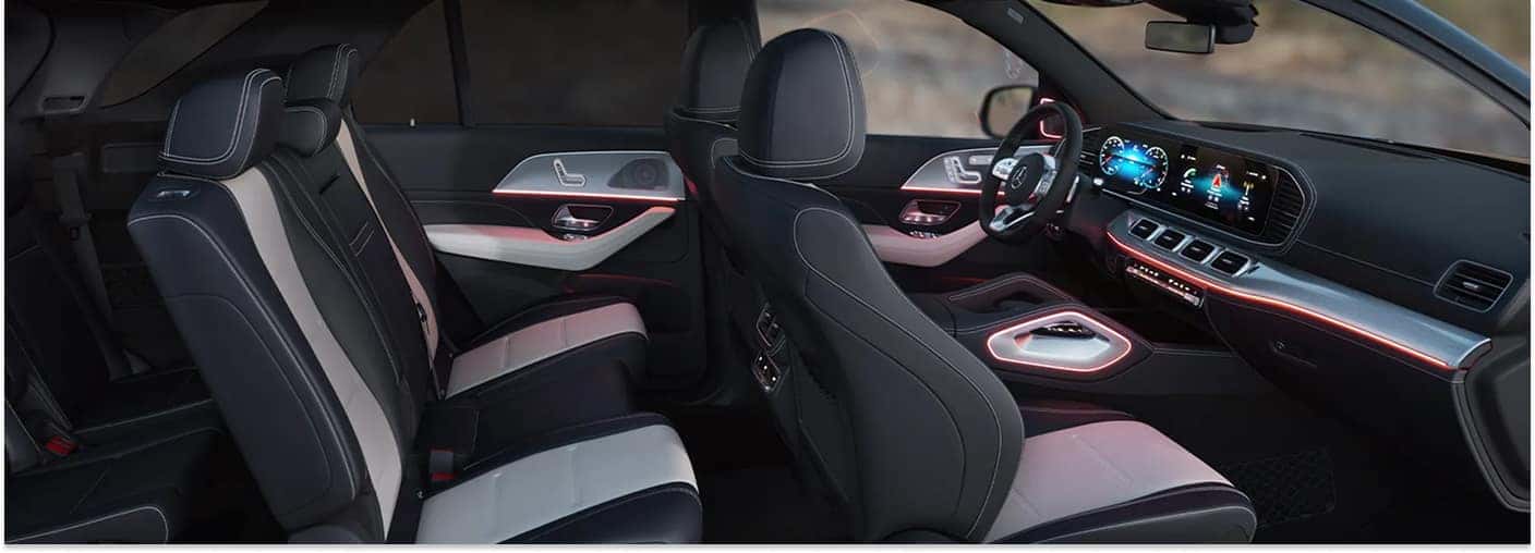 Two-tone black and white leather interior of a 2026 Mercedes-Benz GLE SUV with red ambient lighting.