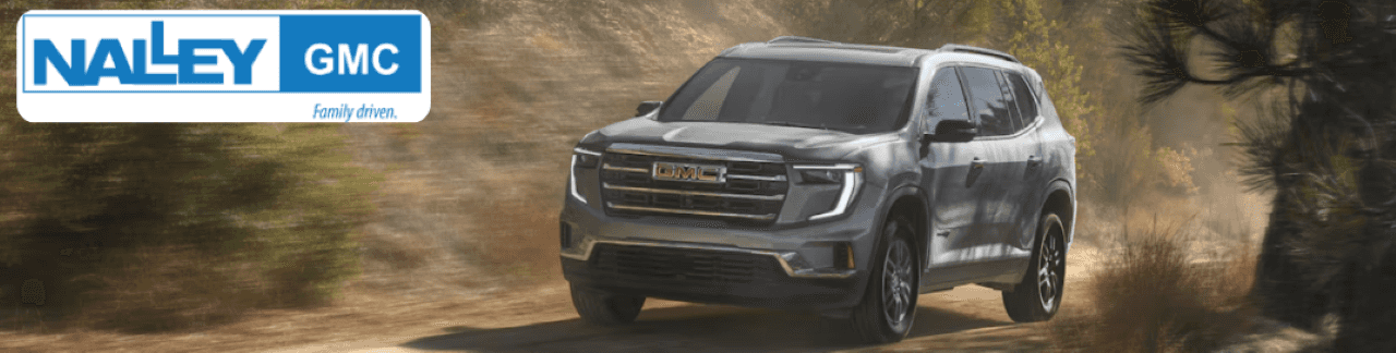 A sleek, pre-owned GMC Acadia SUV on the road in a scenic Brunswick, GA backdrop.