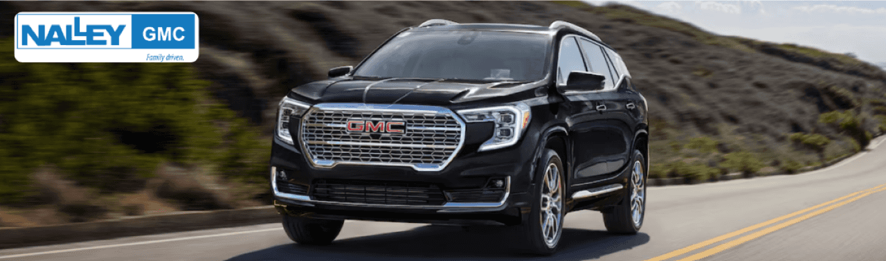 Close-up of a GMC Denali SUV parked in front of Nalley GMC, highlighting its premium design and features.