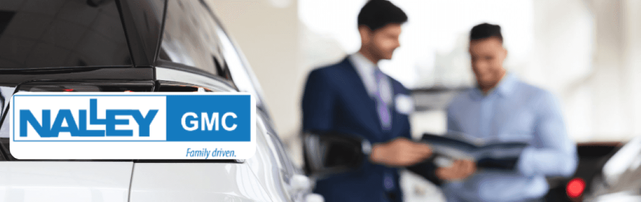 An interior view of the Nalley GMC dealership in Brunswick highlights a friendly staff member assisting a customer with GMC SUV Terrain details.