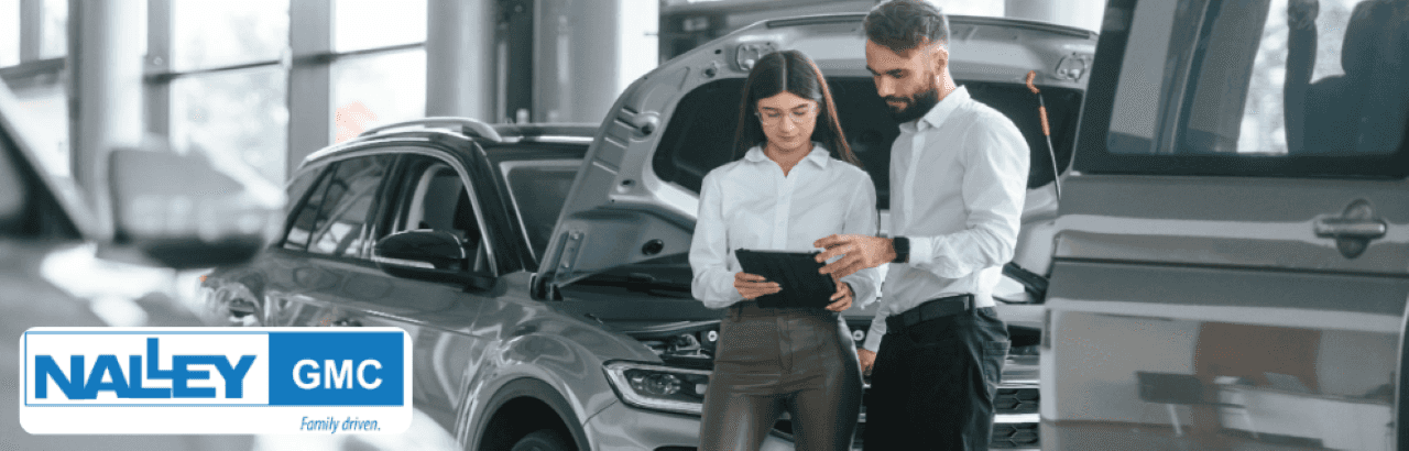 Interior of Nalley GMC showroom in Brunswick, GA, with a friendly staff member assisting customers near a new GMC Sierra truck.
