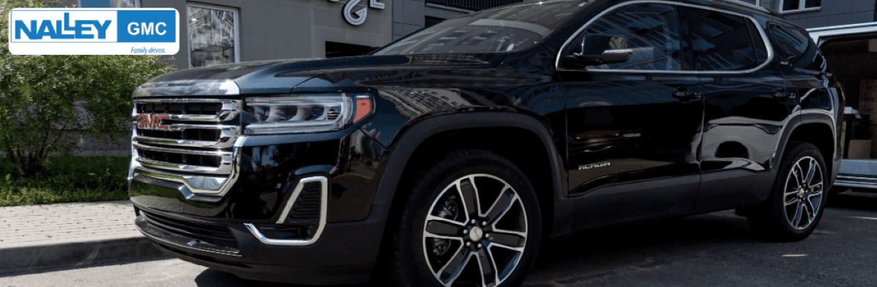 A sleek, pre-owned GMC Acadia SUV in front of Nalley Buick GMC dealership in Brunswick, GA.