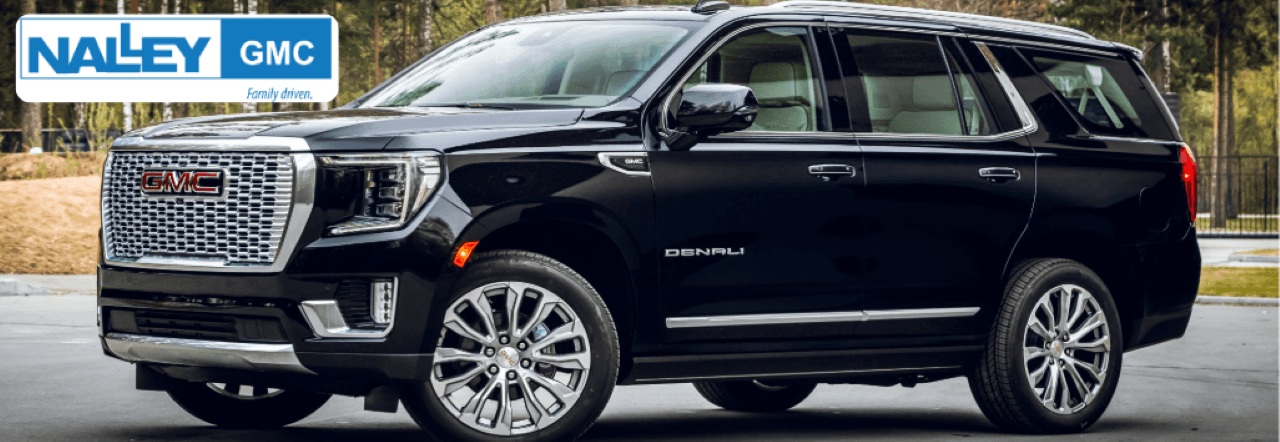 A sleek pre-owned GMC Yukon Denali parked in front of Nalley GMC dealership in Brunswick, GA.