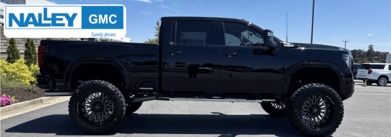 Sales associate presenting a certified pre-owned GMC Truck with a Carfax report in Brunswick, GA