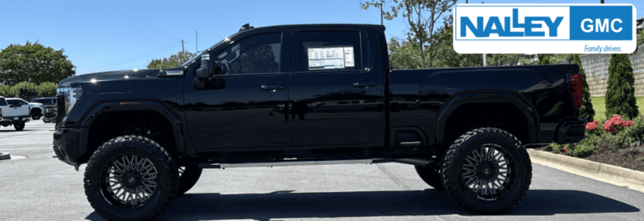 Carfax report shown alongside a used GMC Sierra at the Nalley Brunswick GMC dealership lot