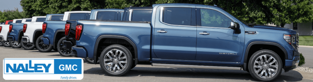 Row of certified pre-owned GMC trucks for sale at Nalley Brunswick GMC in Georgia.