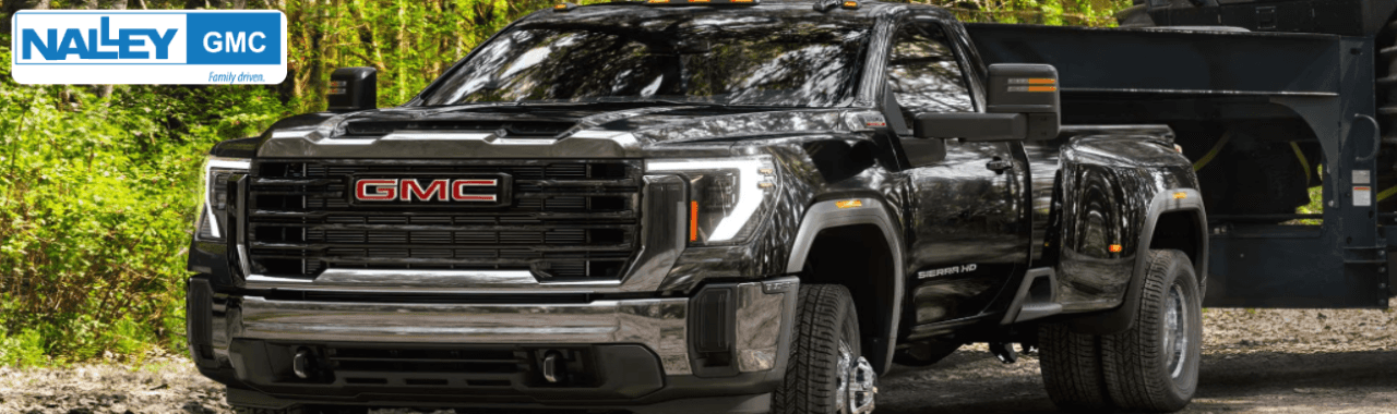 A 2025 GMC Sierra 3500 HD parked on rugged terrain showcases its high ground clearance and towing rig.