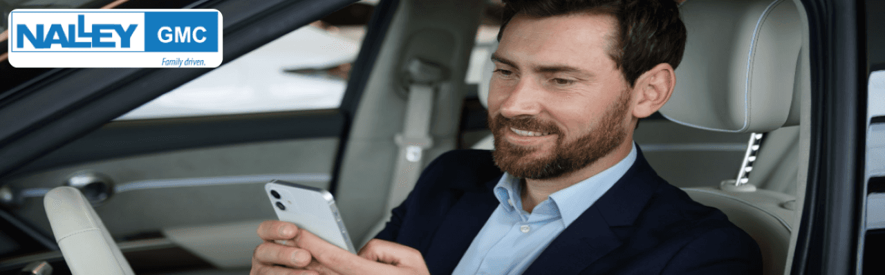 Customer receiving their trade-in appraisal report from a GMC specialist inside the dealership showroom.