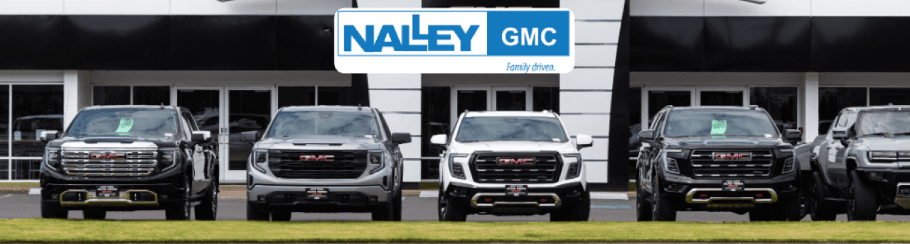 Front angle of all GMC trucks parked near Brunswick, GA, showcasing their bold grille and rugged stance.