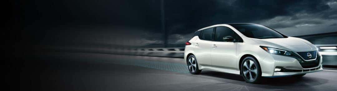 Aerial view of red Nissan Altima turning a street corner