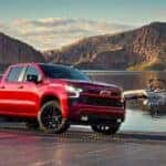 A red 2023 Chevy Silverado 1500 Z71 is shown in front of a lake.