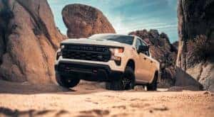 A white 2023 Chevy Silverado 1500 Z71 is shown off-roading.
