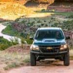 A dark green 2018 Chevy Colorado ZR2 is shown near a river after leaving a used Chevy dealer.