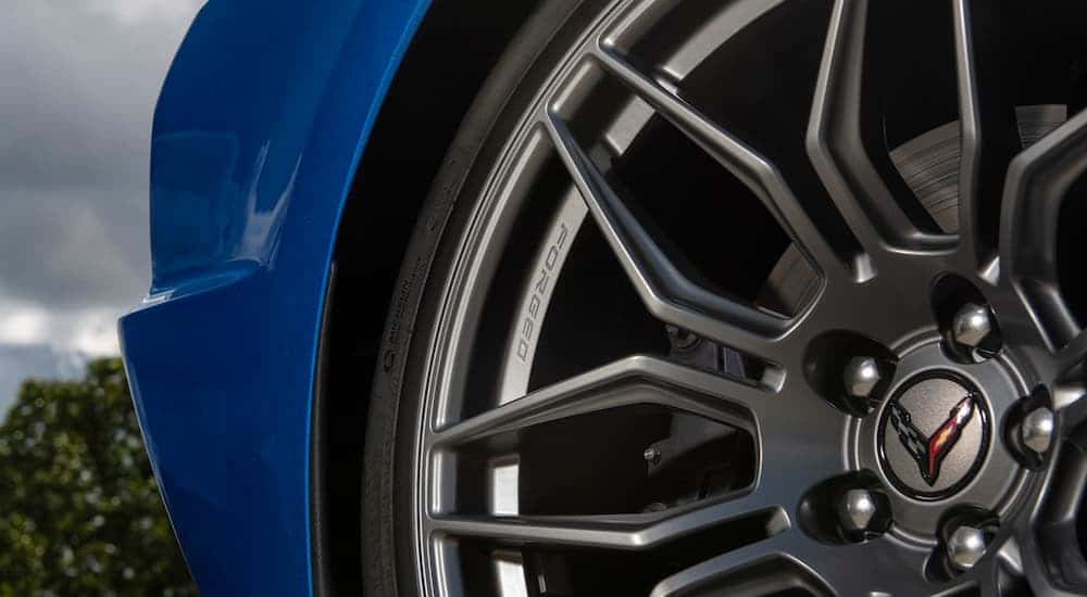 A close up shows the forged wheel on a blue 2023 Chevy Corvette Z06.