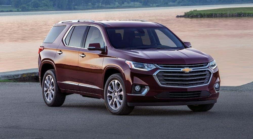 A burgundy 2018 Chevy Traverse is shown parked near a body of water.