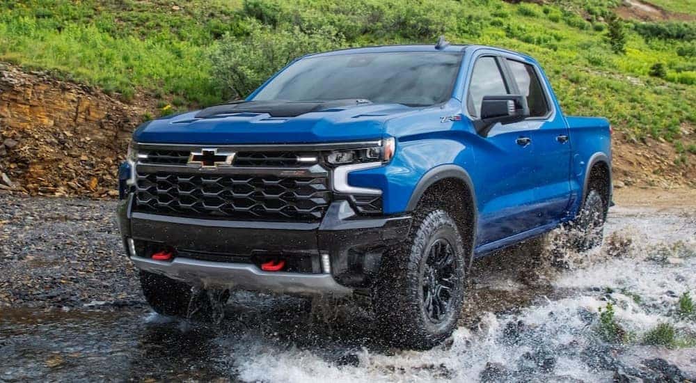 A blue 2022 Chevy Silverado ZR2 is shown off-roading.