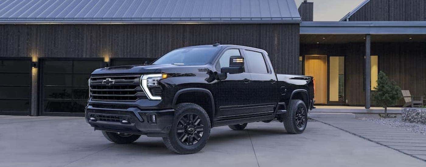 A black 2024 Chevy Silverado 2500 HD High Country Midnight Edition is shown from the front at an angle.