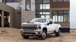 A white 2024 Chevy Silverado 3500 HD LTZ is shown from the front at an angle after leaving a dealer that has heavy duty trucks for sale.