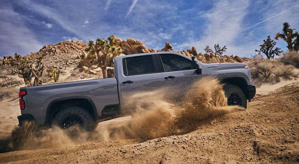 A grey 2024 Chevy Silverado 2500 HD ZR2 is shown from the side after leaving a dealer that has a heavy duty trucks for sale.