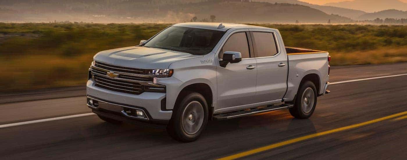 A white 2019 Chevy Silverado 1500 is shown driving on an open road.