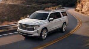 A white 2021 Chevy Suburban is shown from the front at an angle after leaving a dealer that has Chevy SUVs for sale.