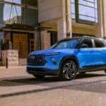 A popular Chevy SUV for sale, a blue 2024 Chevy Trailblazer RS, is shown parked near a building.