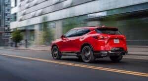 A red 2020 Chevy Blazer RS is shown from the rear at an angle driving through a city.