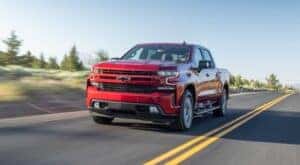 A red 2020 Chevy Silverado 1500 is shown from the front at an angle after leaving a dealer that has used Chevy trucks for sale.